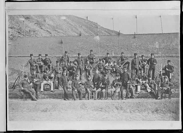 Reprodukce fotografie vojáků, na sudu: Tábor, J. K. 1880 31.1, Na druhém sudu:K.K.b.I.W. BAON, Tabor No 46 na sudu: Tábor, J. K. 1880 31.1, Na druhém sudu:K.K.b.I.W. BAON, Tabor No 46  skupina,voják