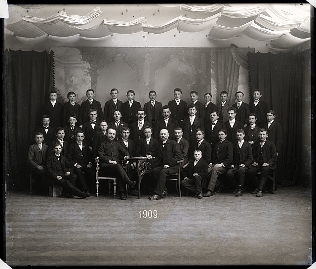 Ateliérový snímek - skupina zimní školy 1909  Na krabičce: 613, 205 v kroužku 11ks-sklo  - Odbočka U.J.Č.Č (číšníci) - plesový... skupina