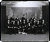  - Ateliérový snímek - tamburaši s p. Heřmánkem s nástroji (15 mužů), částečně prasklá