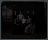 Ateliérové foto - 7 členů rodiny (1 sedící batole, 2 ženy sedící, 1 žena stojící, 3 muži s kníry, stojící)