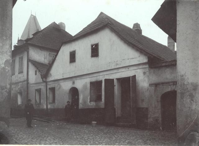 Dům číslo 34, v pozadí radniční věž
K číslu 34 patřilo v roce 1905 přídomčí vlevo a jedna místnost v přízemí
   Staré město