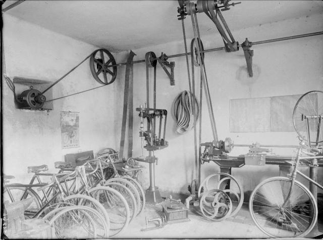výroba kol   Ten snímek přesně charakterizuje tehdejší dílny cyklomechaniků. Opravovali šicí... interier, kola, výroba