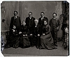 Ateliér. foto - 3 ženy (sedící), muž uprostřed, vzadu stojící 4 muži